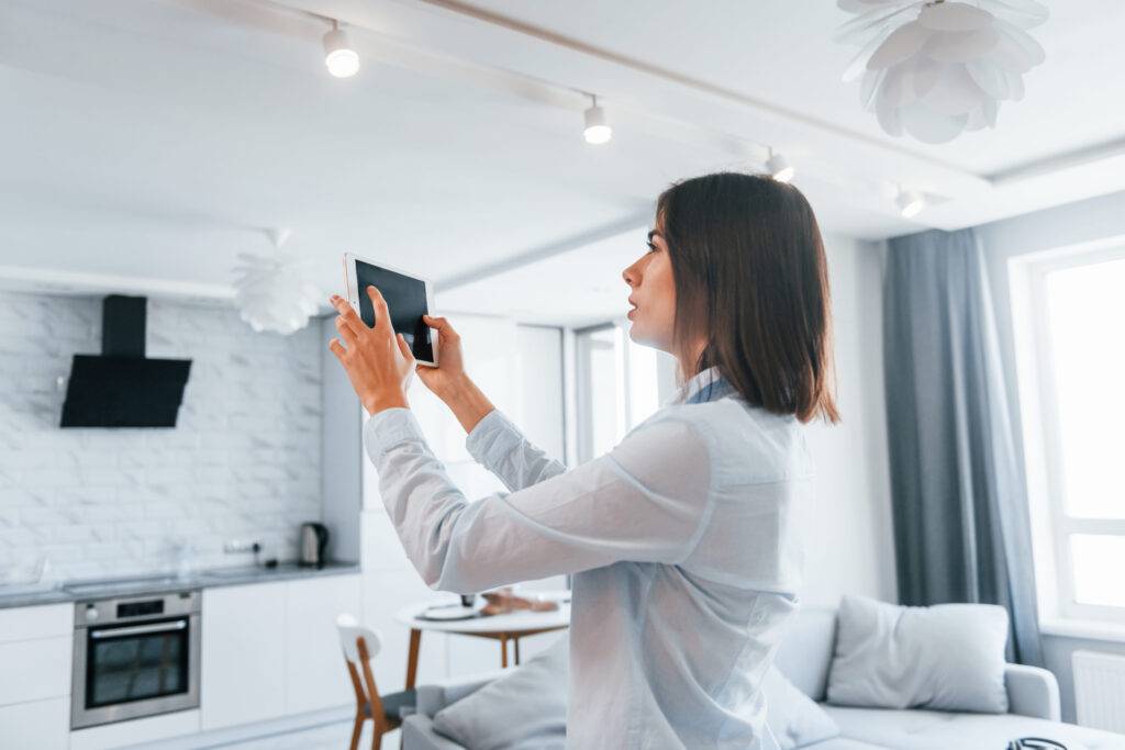 Woman controlling the light through a tablet